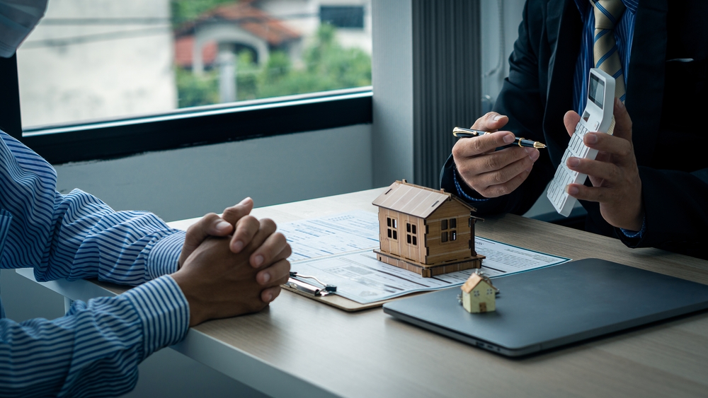 Sales agents offer interest rate contracts on home installments and home purchases for clients to sign contracts in real estate agencies. mortgage concept house purchase contract