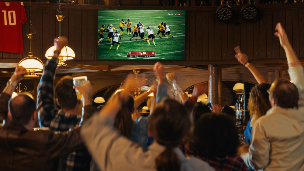 fans watching football game at bar